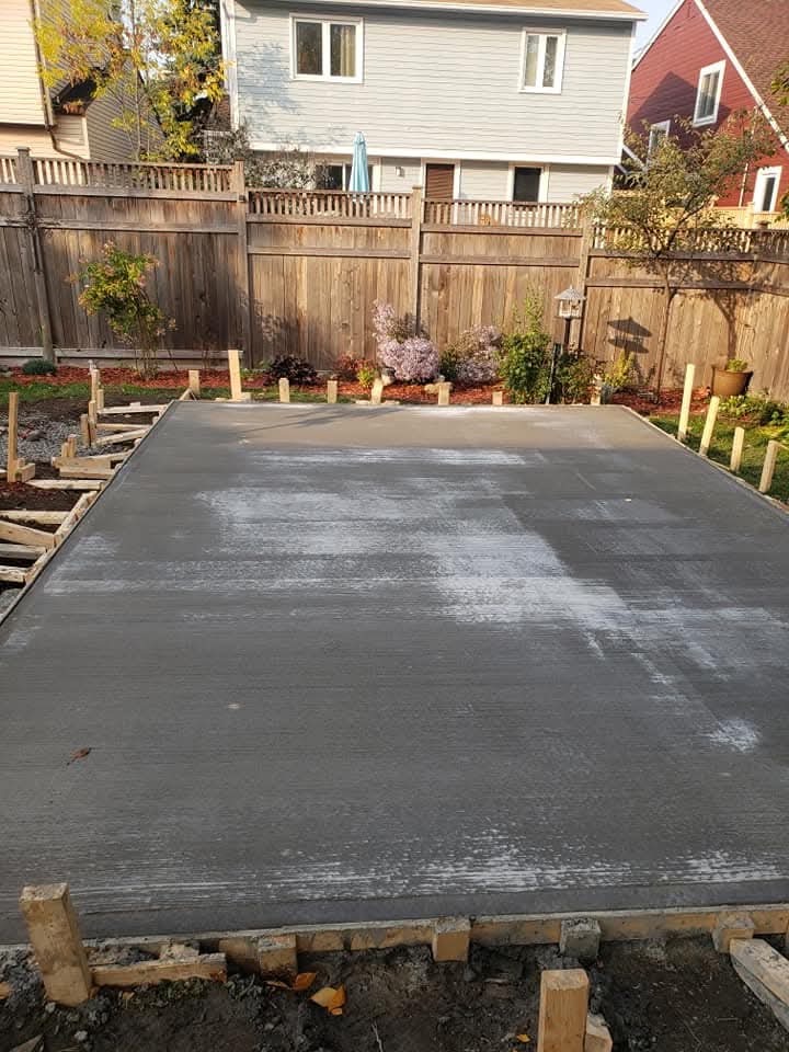 Fresh rectangular backyard concrete slab with finishing marks and timber forms visible