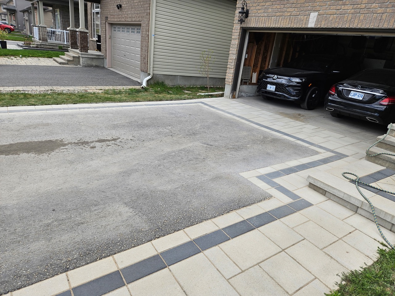 Interlock walkway and contrasting border beside a driveway and front entrance